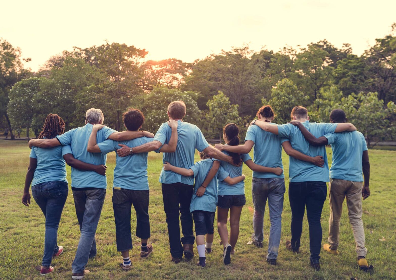 group of people walking away from camera blue shirts community 